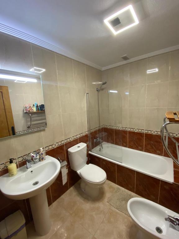 a bathroom with a toilet and a sink and a tub at Parque De Las Naciones Dragon con garaje ! in Torrevieja