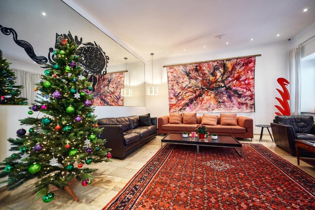 a christmas tree in a living room with a couch at Hotel Kunsthof in Vienna