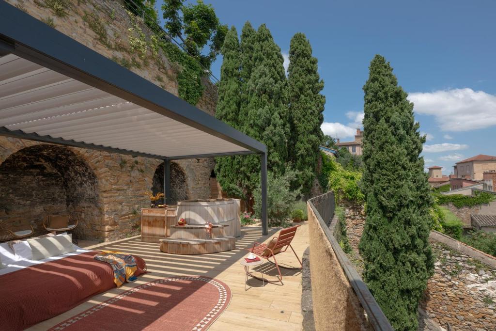 an outdoor deck with a bed and a grill at MiHotel - La Maison Rose in Lyon