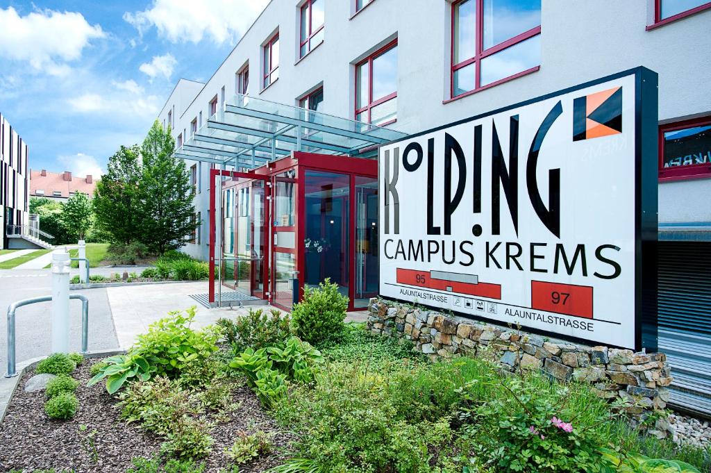クレムス・アン・デア・ドナウにあるKolping Campus Kremsの駐車場のカーンを読む看板のある建物