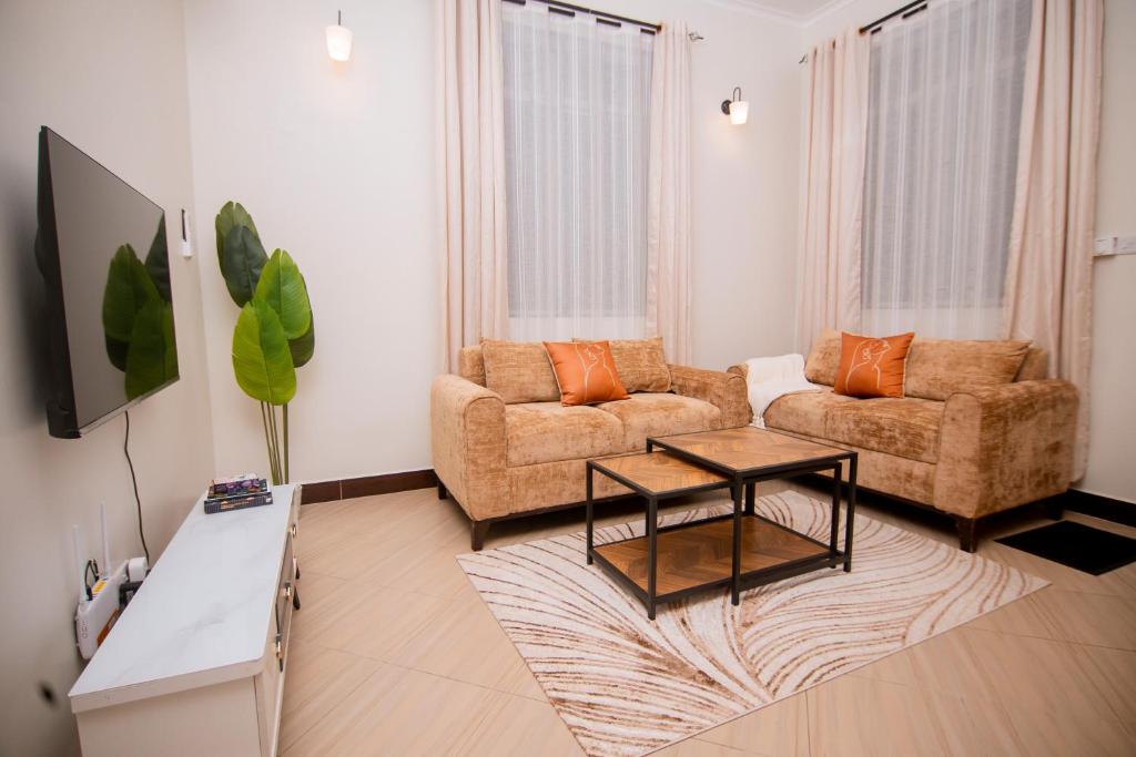a living room with two couches and a coffee table at Reza stays apartment -Makumbusho behind Mwanga Tower in Dar es Salaam
