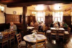 um grupo de pessoas sentadas em mesas em um restaurante em Gasthof Anker em Miltenberg