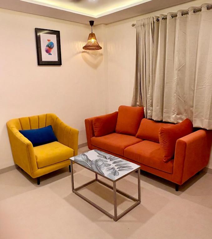 two chairs and a couch and a table in a living room at Aesthetic 1BHK Elite, Indore in Indore