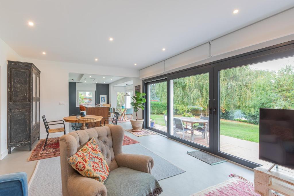 a living room with a large window and a tv at Errekaondo - baskeyrentals in Plentzia