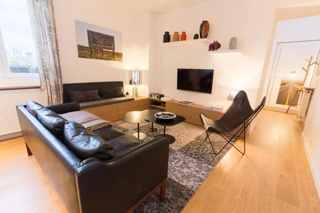 a living room with a leather couch and a television at 18 Crebillon in Nantes