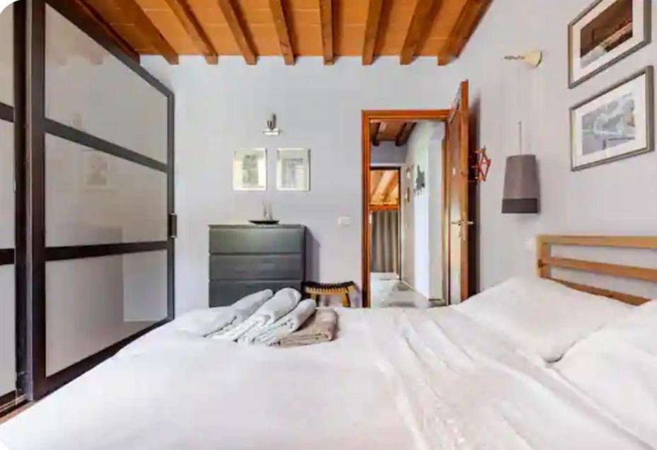 a bedroom with two white beds and a television at Casa Gelsomino in Scandicci