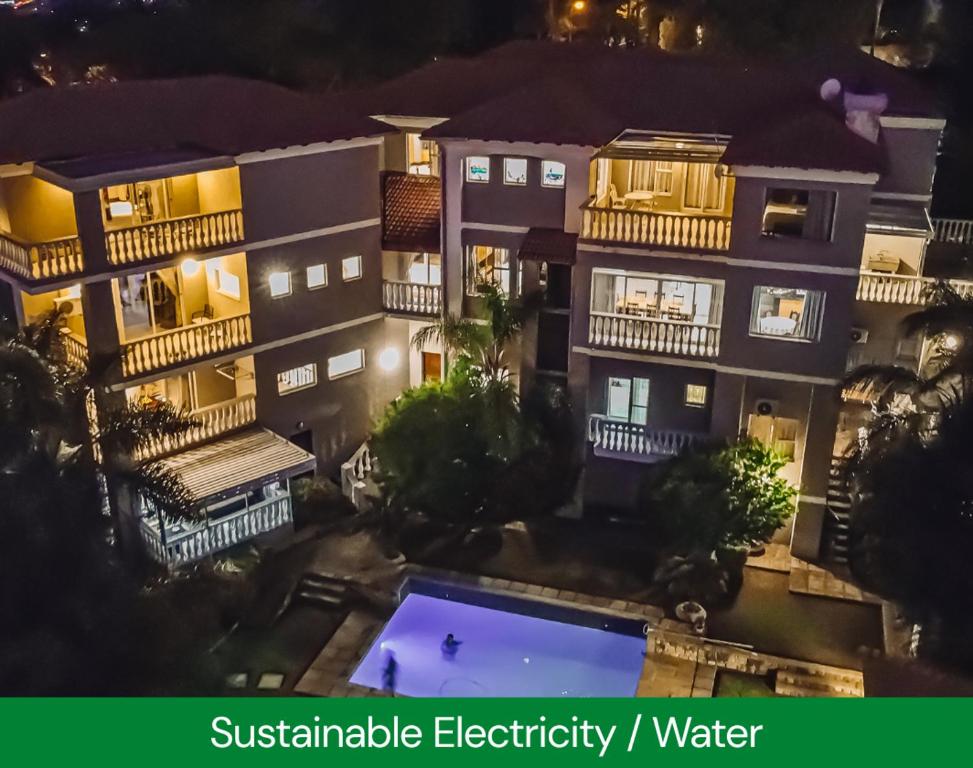 an apartment building with a swimming pool at night at All Seasons Boutique Hotel - Own Water - Own Electricity in Pretoria