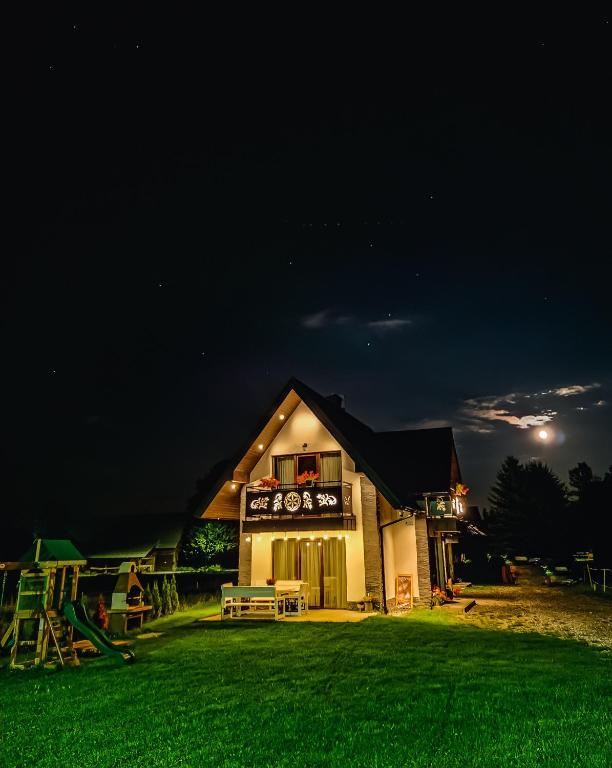 a house at night with a green grass yard at Family HOUSE in Witów