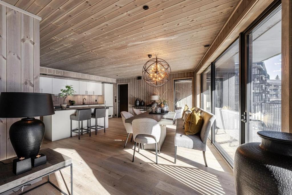een woonkamer met houten plafonds en een groot raam bij Brand new luxury apartment by the slopes, Hemsedal in Kyrkjebøen