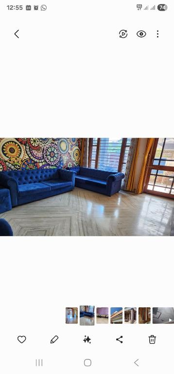 a blue couch is sitting in a room at Holiday home in posh area of Dehradun in Dehradun