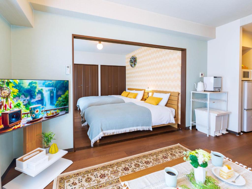 una camera da letto con due letti e una TV a schermo piatto di NicoRoom601-Convenient location a Takamatsu