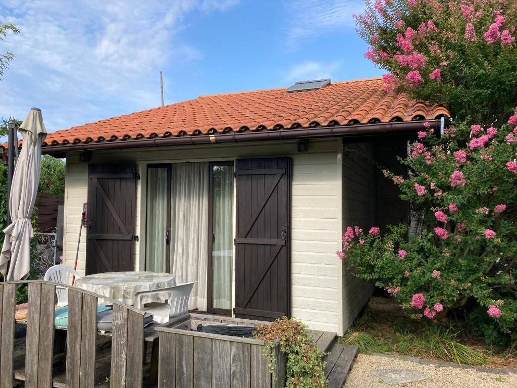 a small house with a table and a fence at Duplex proche du port in Audenge
