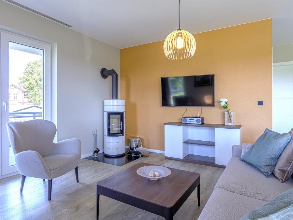 a living room with a couch and a tv at Strandliebe - 5 Sterne Ferienwohnung - Urlaub zwischen Ostsee und Bodden in Wustrow