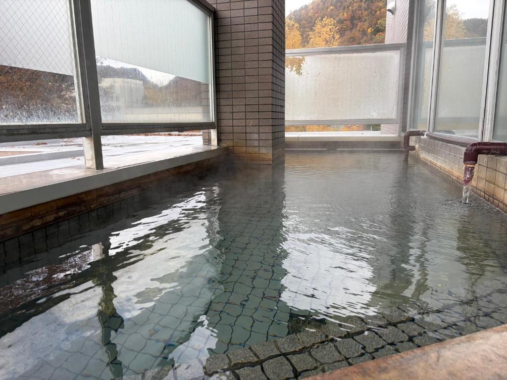 a pool of water in a room with windows at フューデイズコンドミニアム定山渓211号室(最大5名まで） in Jozankei