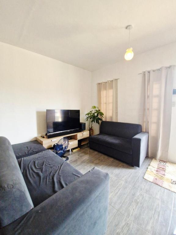 een woonkamer met twee banken en een flatscreen-tv bij Cozy Studio with Queen Bed in Malaybalay City 