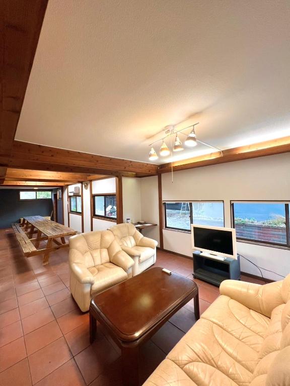 a living room with two couches and a tv at 波浮とみや 全部屋個室 伊豆大島 in Oshima