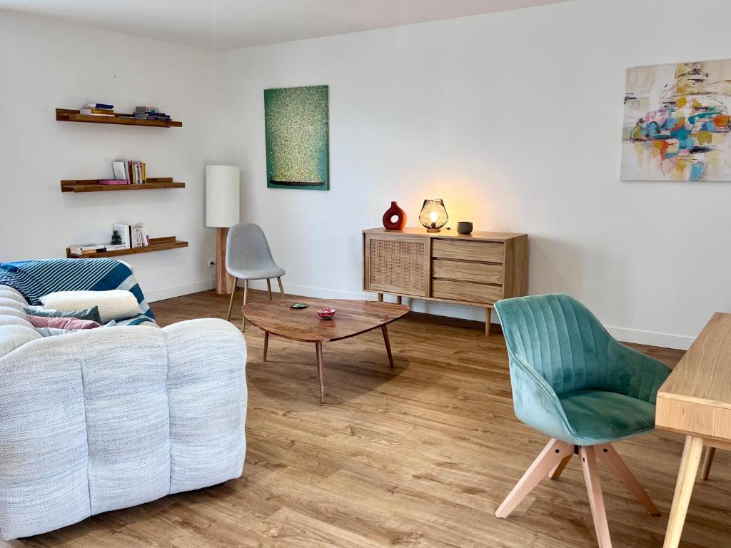 una sala de estar con un sofá y una mesa en Maison avec grand jardin en centre ville, en Le Blanc