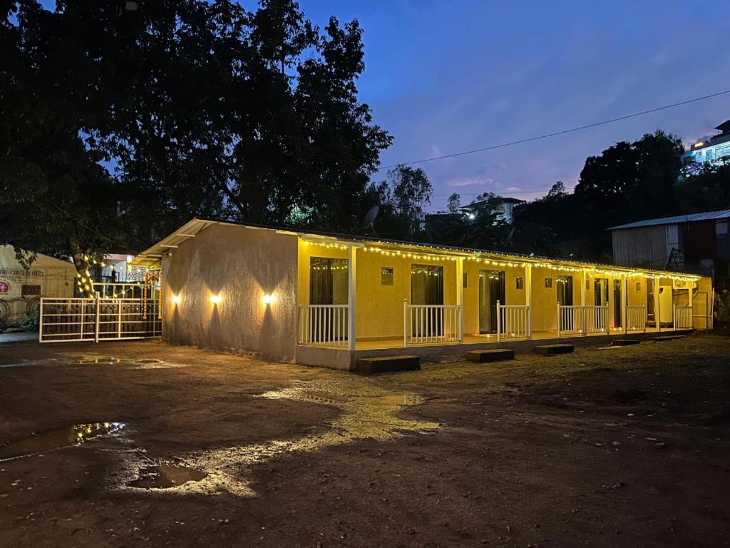un grand bâtiment jaune avec des lumières dessus dans l'établissement WKND Casa, à Panchgani