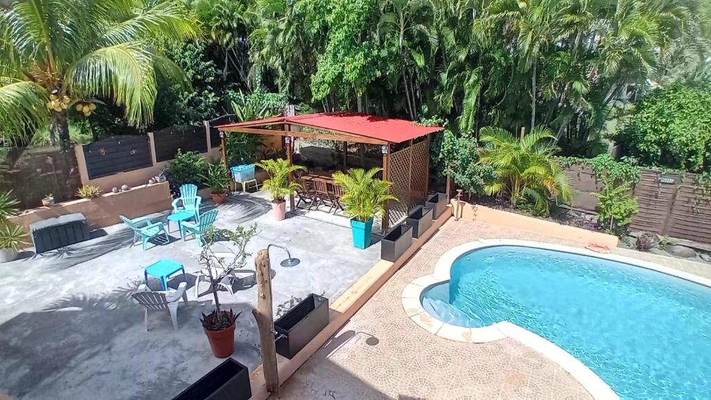 a swimming pool with a gazebo next to a swimming pool at L'Oasis de L'Anse Bleue in Le Diamant