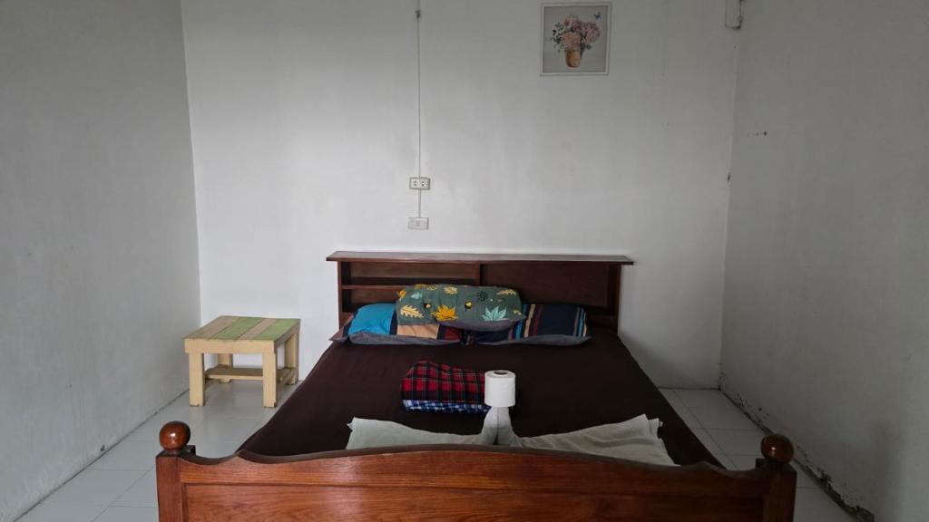 a small bedroom with a bed and a table at Sunny hostel in Pai
