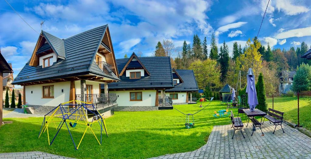 a house with a yard with a playground at Domki przy Potoku in Suche