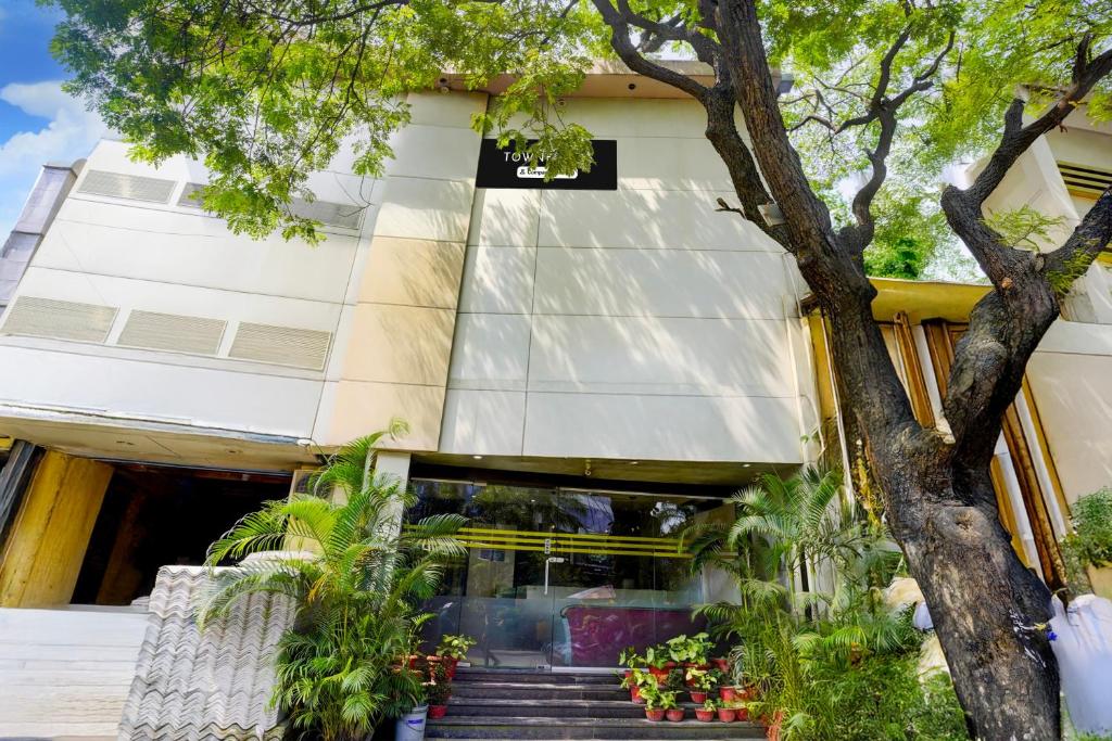 a building with stairs in front of a tree at Townhouse Andheri Sakinaka Metro Formerly Hotel Amour in Mumbai