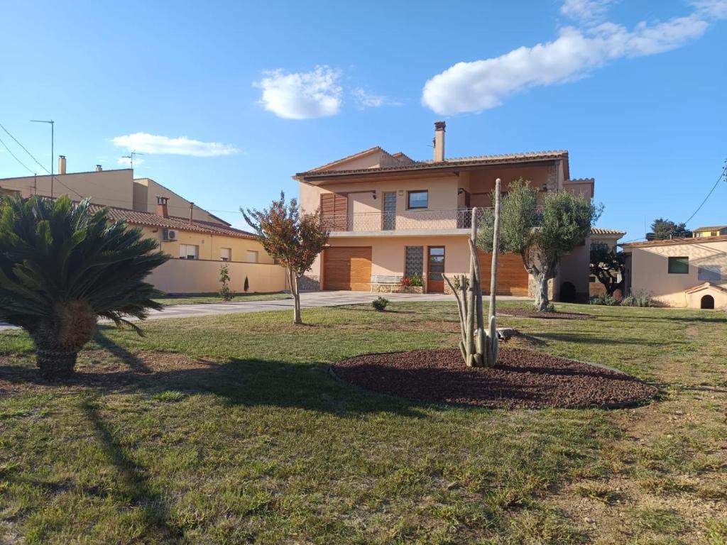 a house with a palm tree in a yard at El Roure in Navata