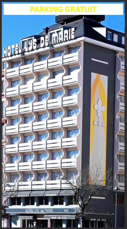 a large building with a sign on the side of it at Hôtel Lys de Marie in Lourdes