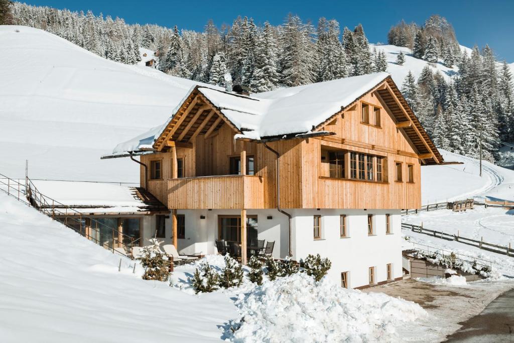 a wooden house in the snow with trees at Mountain Chalet Pia in La Valle
