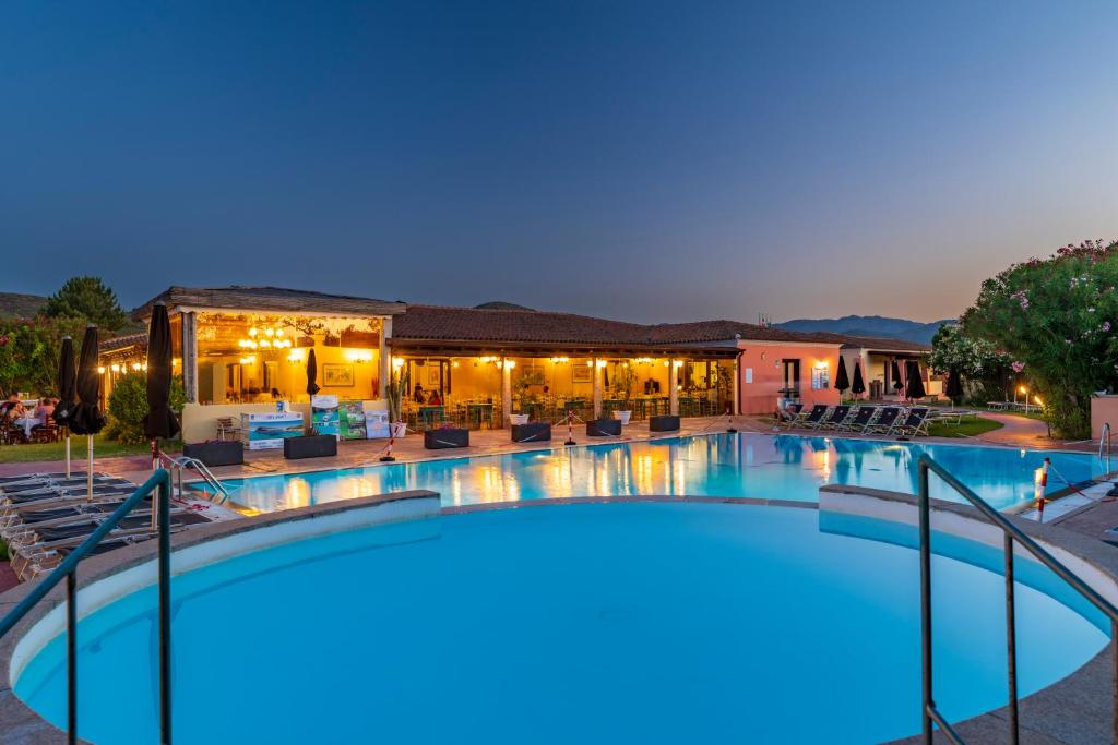 ein großes Schwimmbecken vor einem Gebäude in der Unterkunft Li Suari Club Village in San Teodoro