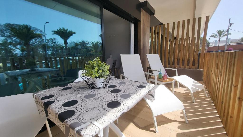 een tafel met een vaas op een patio bij Sunset Arguineguin by CanariasGetway in Arguineguín