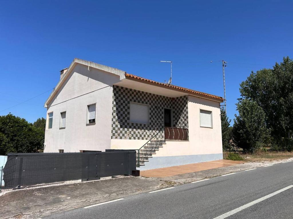 a small white house with stairs on the side of a road at Casa Vale de Água em Santarém in Santarém