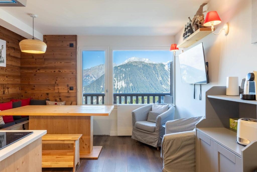 a kitchen with a table and a view of a mountain at La Foret du Praz 501 in Courchevel