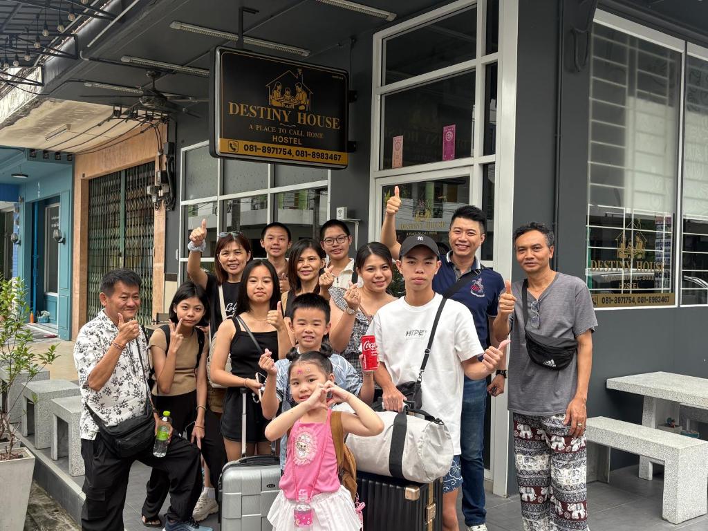 un gruppo di persone che posano per una foto fuori da un edificio di Destiny House Hostel a Hat Yai