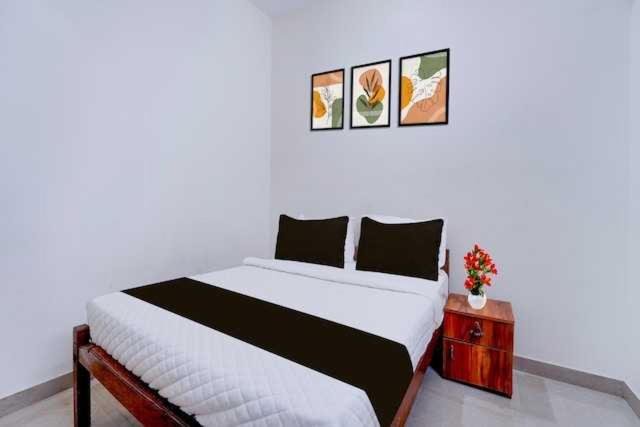 a bedroom with a large bed and a night stand at Hotel O Kallar Vattiyar Waterfalls Munnar in Munnar