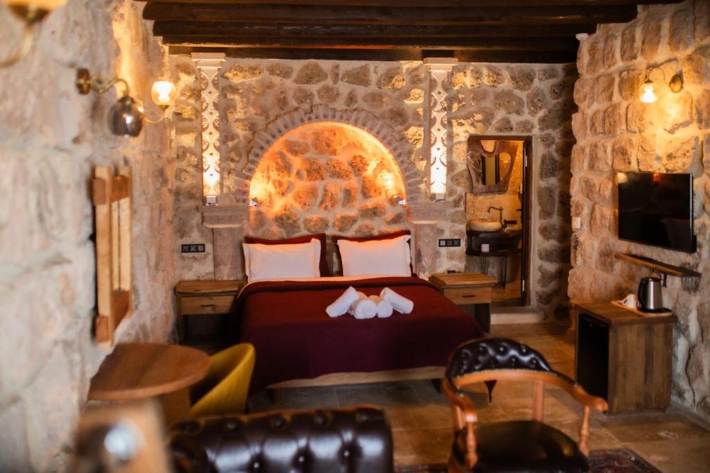 a bedroom with a bed in a stone room at Rose Moon Cave in Macun Çiftliği