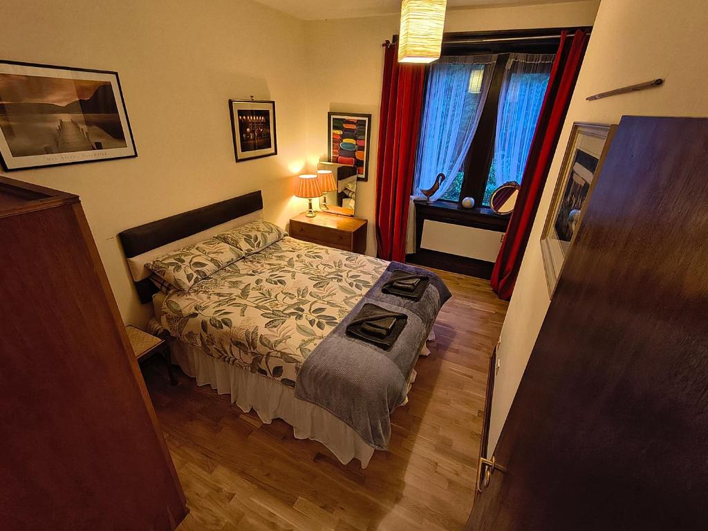 Un dormitorio pequeño con una cama y una ventana. en A Baronial Hall apartment - great views of Loch Fyne, 