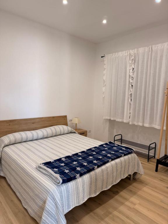 a bedroom with a bed with a blue blanket on it at Ca' dei lecci in Tuoro sul Trasimeno