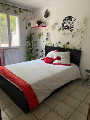 une chambre avec un lit avec des oreillers rouges et blancs dans l'établissement Villa des Rosiers, à La Celle-sous-Gouzon