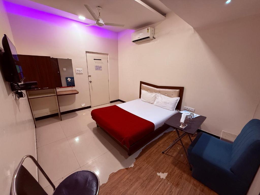 Una pequeña habitación con una cama y sillas. en Hotel SK Galaxy Thane West, en Thane