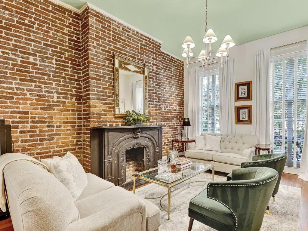 a living room with a brick wall and a fireplace at Gordon Inn Live Oak in Savannah