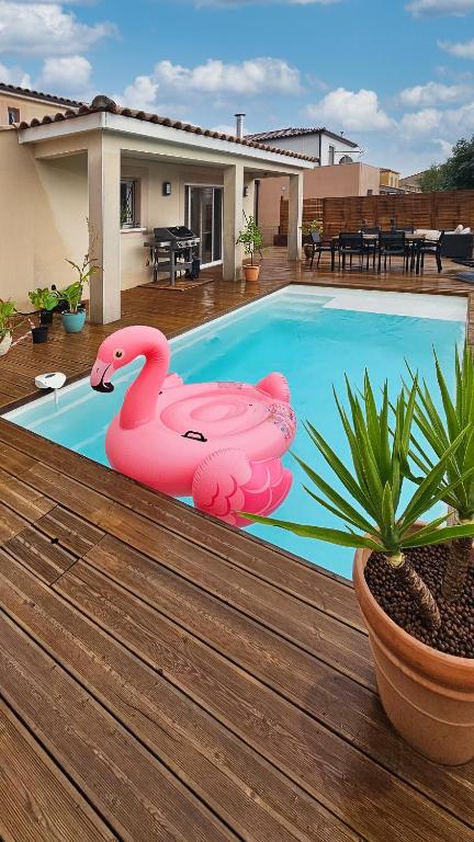 a pink flamingo pool float sitting on the deck of a house at Villa Gina in Garons