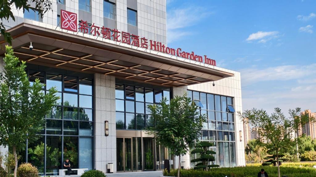 a building with a sign on top of it at Hilton Garden Inn Lanzhou Anning in Lanzhou