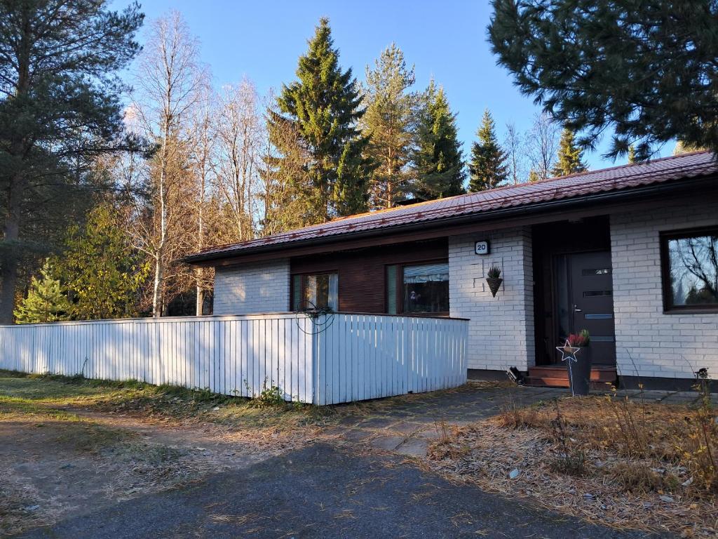 a house with a white fence in front of it at NorthSlope in Rovaniemi