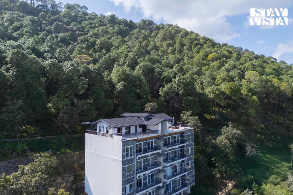 an aerial view of a building in front of a mountain at StayVista at Raga Living - Mountain Views, Bonfire in Parwanoo