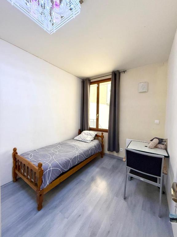 a bedroom with a bed and a desk at Face à la gare - Chambre 3 in Roanne