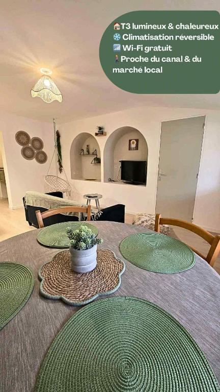 a table with green plates on top of it at Bohême en cœur de ville in Castelsarrasin