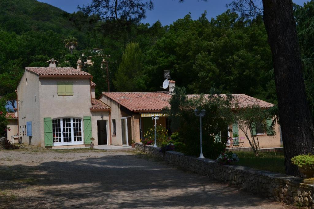 a house with a tree in front of a driveway at villa Léonfine in Le Cannet-des-Maures