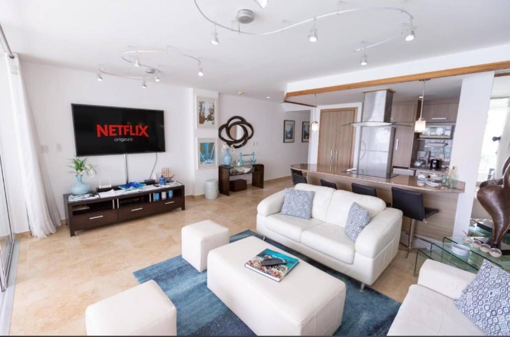 un salon avec un canapé et une télévision dans l'établissement Beachfront Apartment Marbella, Juandolio, à Villas del Mar