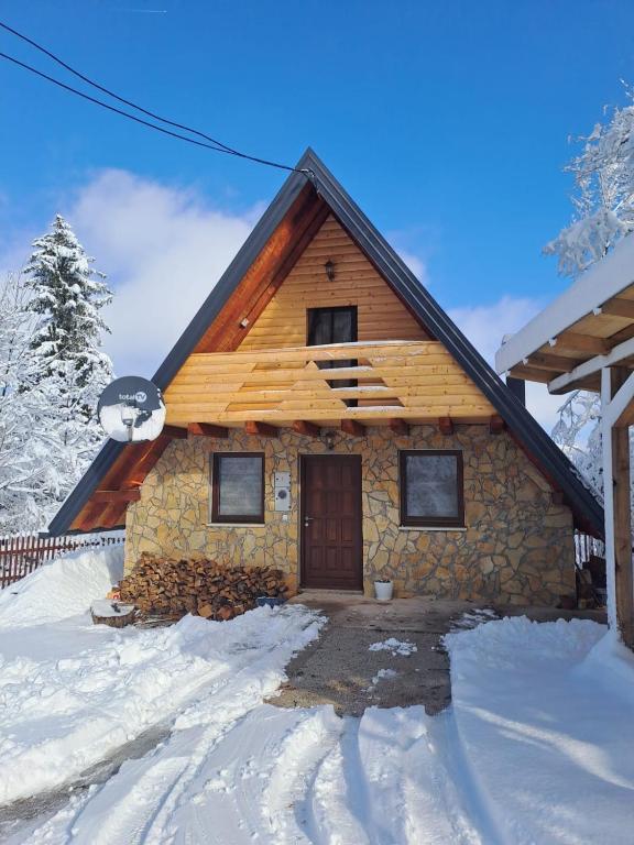 a log cabin in the snow with a door at Pogled na Romaniju in Pale